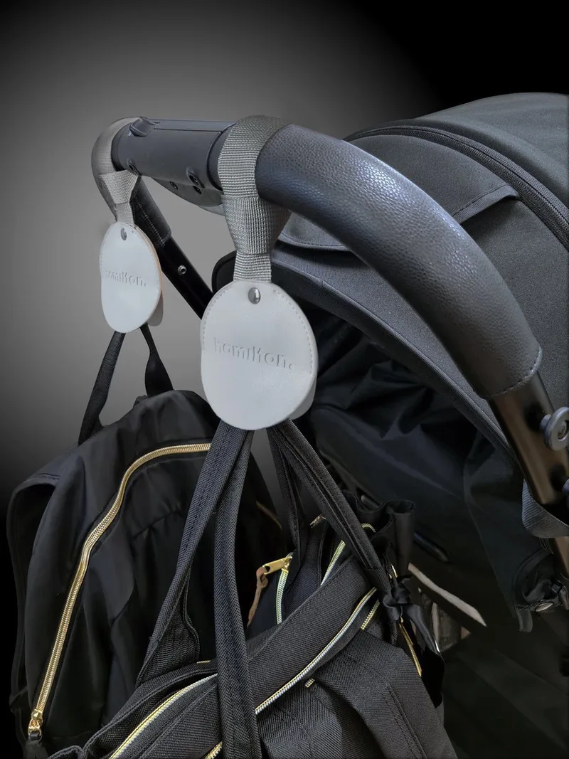 Buggy Haken - Extra Sterke Kinderwagen Ophanghaken tot 20KG - Kindvriendelijke Tassenhaak - Premium Kunstleer - Universele Wandelwagenklem fra Hamilton by Yoop i Wit – produktbillede